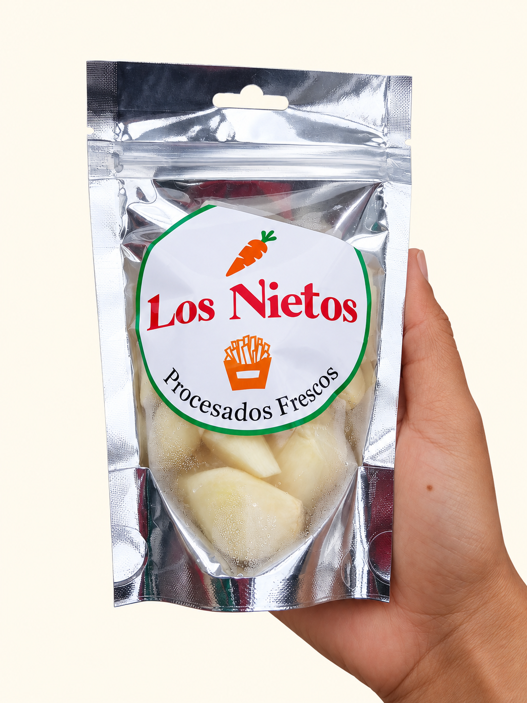 Ajo entero pelado fresco Los Nietos, envase de 120 g sostenido en una mano sobre fondo crema.
