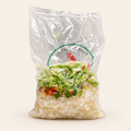 Mix de puerro Los Nietos en bolsa, con cebolla y pimientos picados, sobre fondo crema