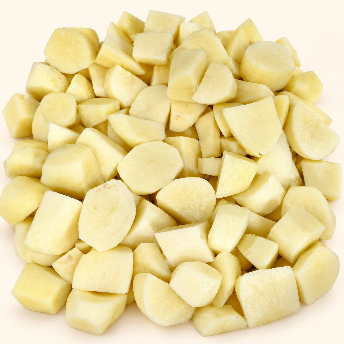 Detalle de papas frescas peladas con corte grande para horno sobre fondo crema.