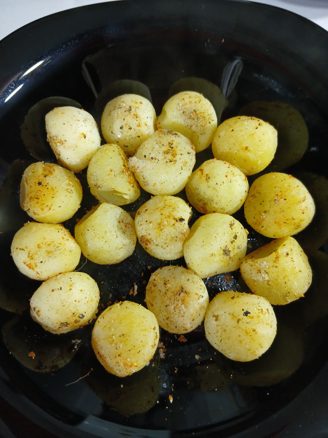Sugerencia de preparación: papas noisette Los Nietos ya cocinadas y condimentadas, servidas en un plato negro