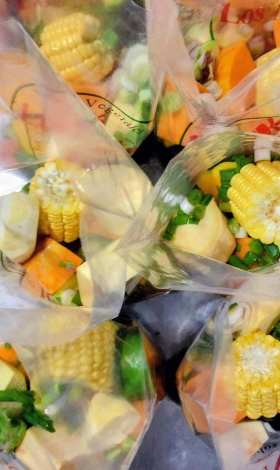 Vista desde arriba de bolsas de vegetales para sopa con choclo visible. Fotografía original sin retoques.
