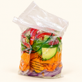 Vegetales frescos para wok Los Nietos, bolsa de 750 g sobre fondo crema.